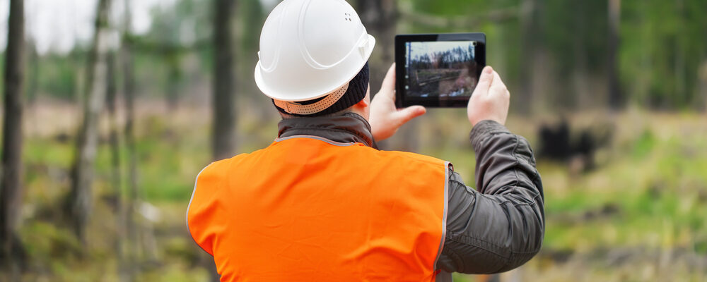 worker taking photo on job site of incident using tablet