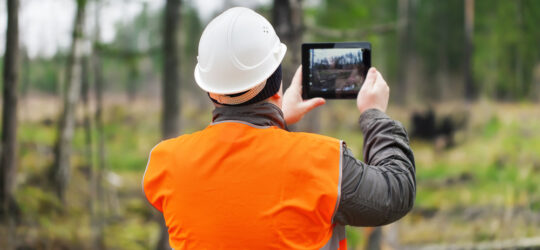 worker taking photo on job site of incident using tablet