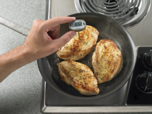 thermometer checking for food safety temperature on chicken