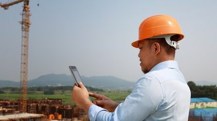Man holding smartphone on construction site
