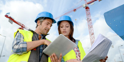 Man and woman working on tablet on construction site for estimates
