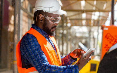 man using tablet on construction site for safety