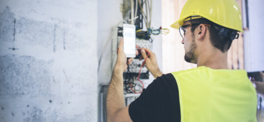 man performing electrical inspection using checklist