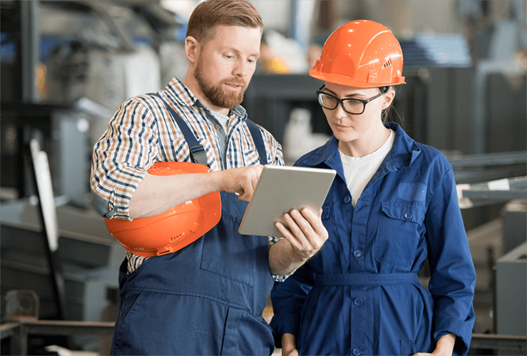 Two maintenance workers looking at a tablet inputing job information using GoCanvas software.